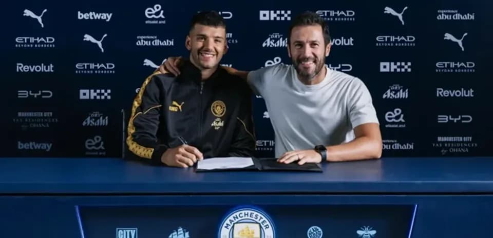 Jugador y entrenador posando en mesa de firma