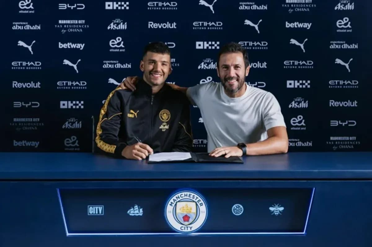 Jugador y entrenador posando en mesa de firma