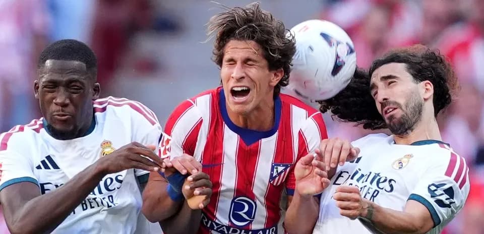 Jugadores de Atlético y Real Madrid disputando el balón