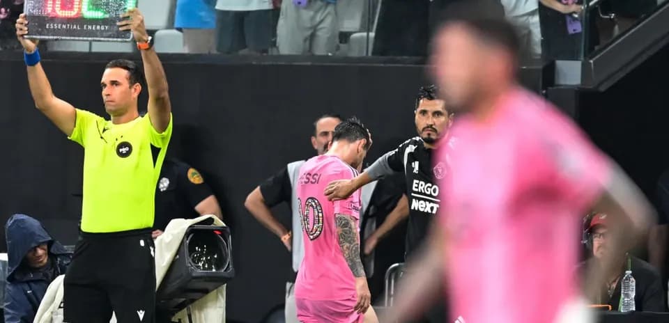 Jugador saliendo del campo con cartel de sustitución