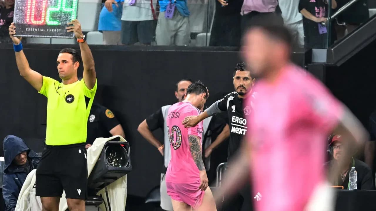 Jugador saliendo del campo con cartel de sustitución