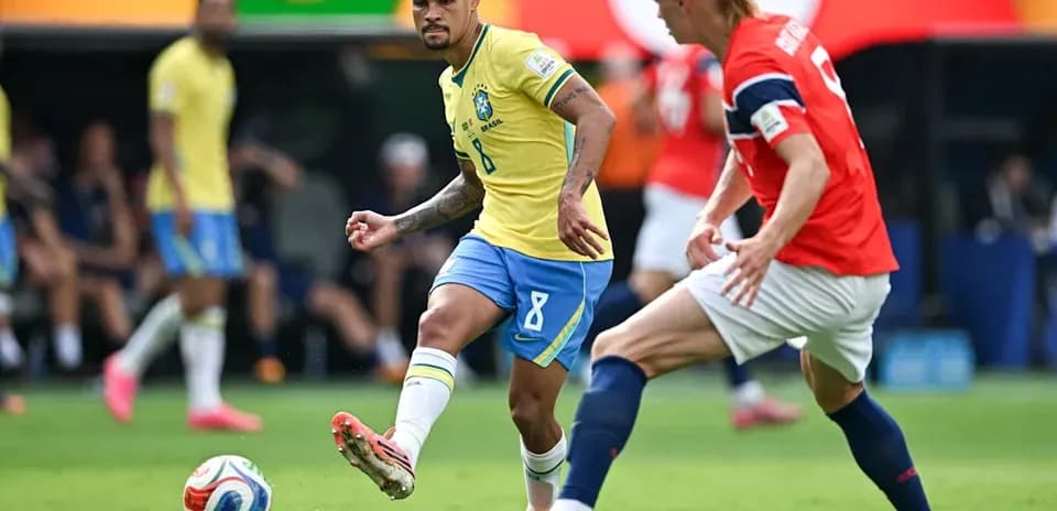 Jugador brasileño driblando a rival noruego en partido