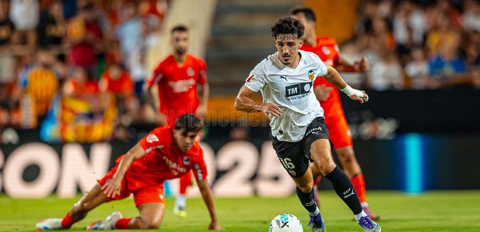 Jugador del Valencia corriendo con el balón