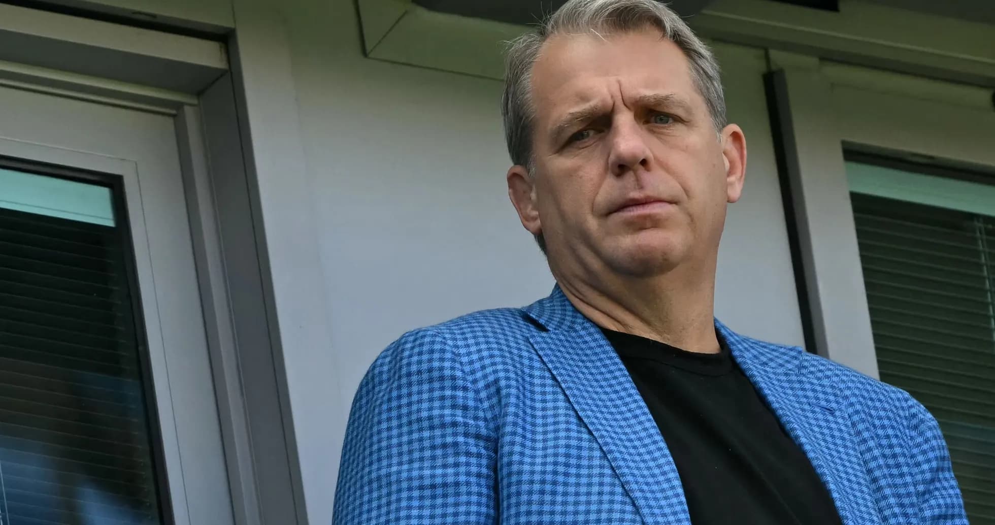 Persona en chaqueta azul observando desde un balcón