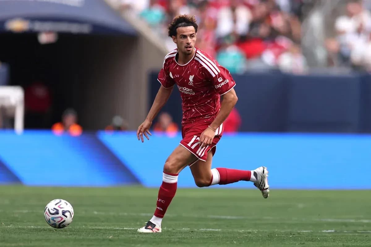 Jugador de Liverpool corriendo con el balón en el campo