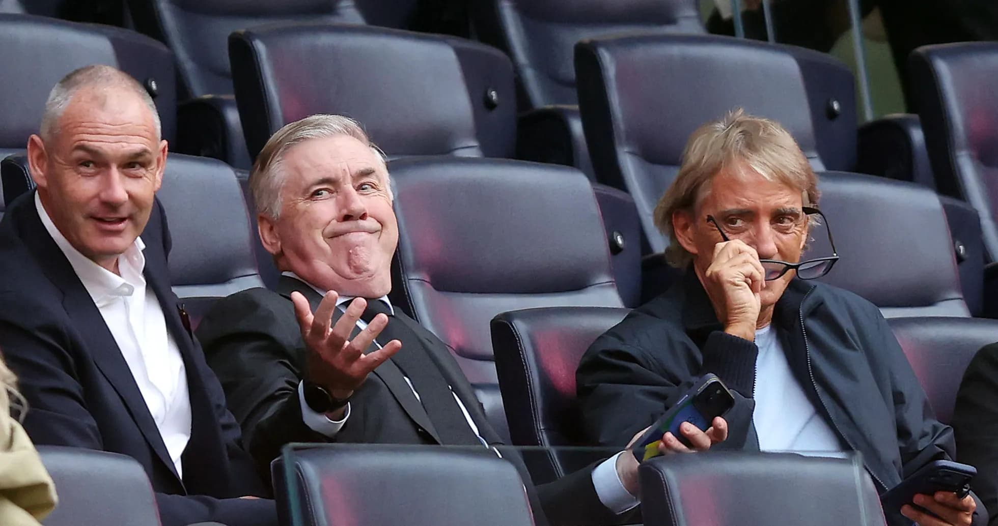 Tres hombres en la grada durante un partido