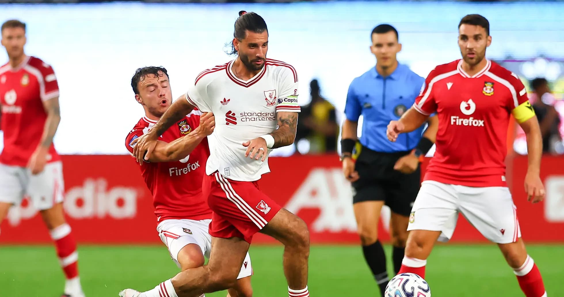 Jugador de Liverpool evadiendo a adversario durante partido