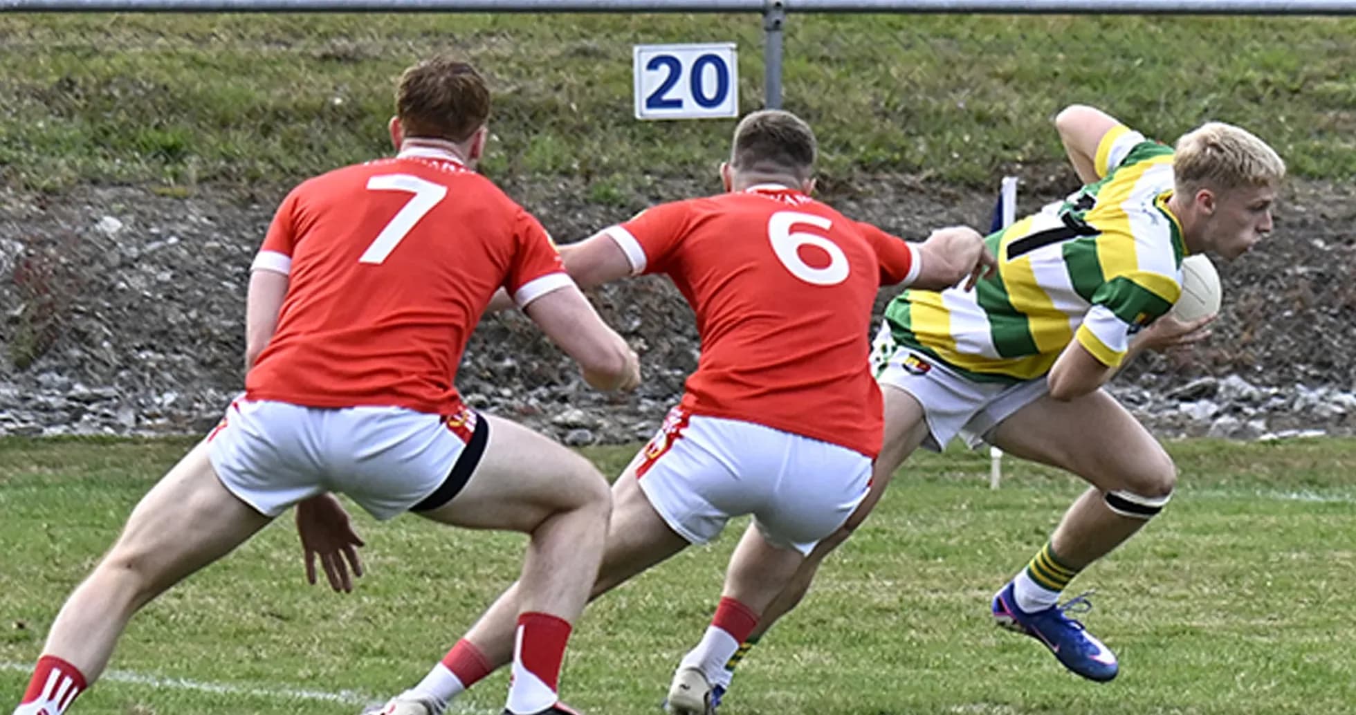 Jugador esquivando a dos oponentes en partido de rugby