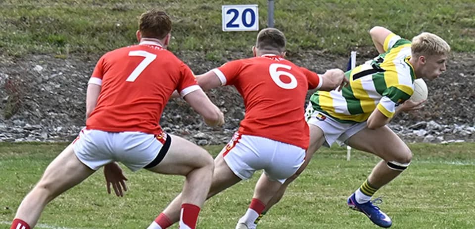 Jugador esquivando a dos oponentes en partido de rugby