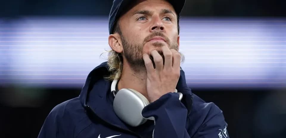 Jugador pensativo con auriculares en el cuello