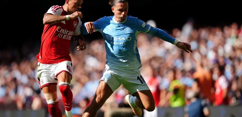 Jugadores de Arsenal y Manchester City compitiendo por el balón