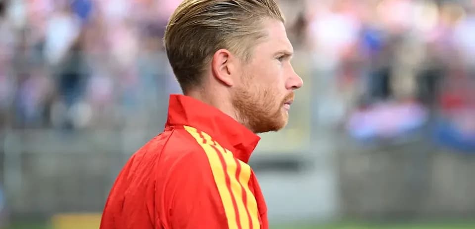 Jugador con chaqueta roja en el campo de fútbol
