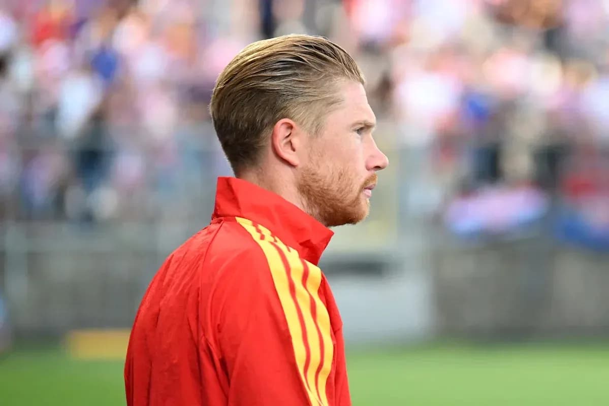 Jugador con chaqueta roja en el campo de fútbol