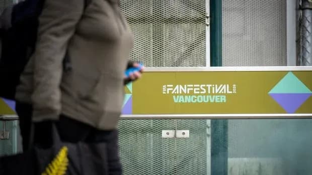 Persona caminando junto al cartel de Fan Festival Vancouver