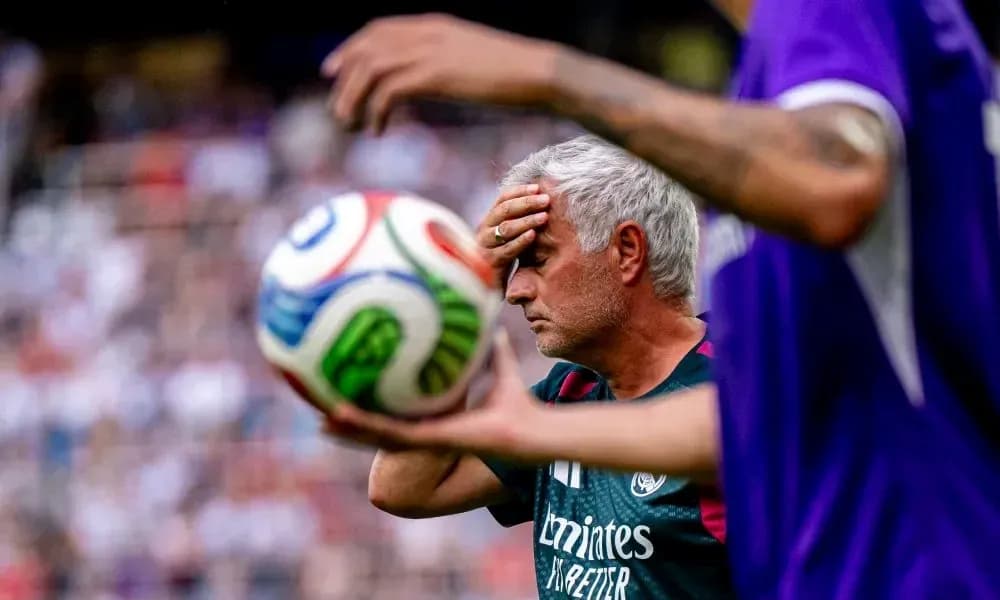 Entrenador con mano en la frente durante partido