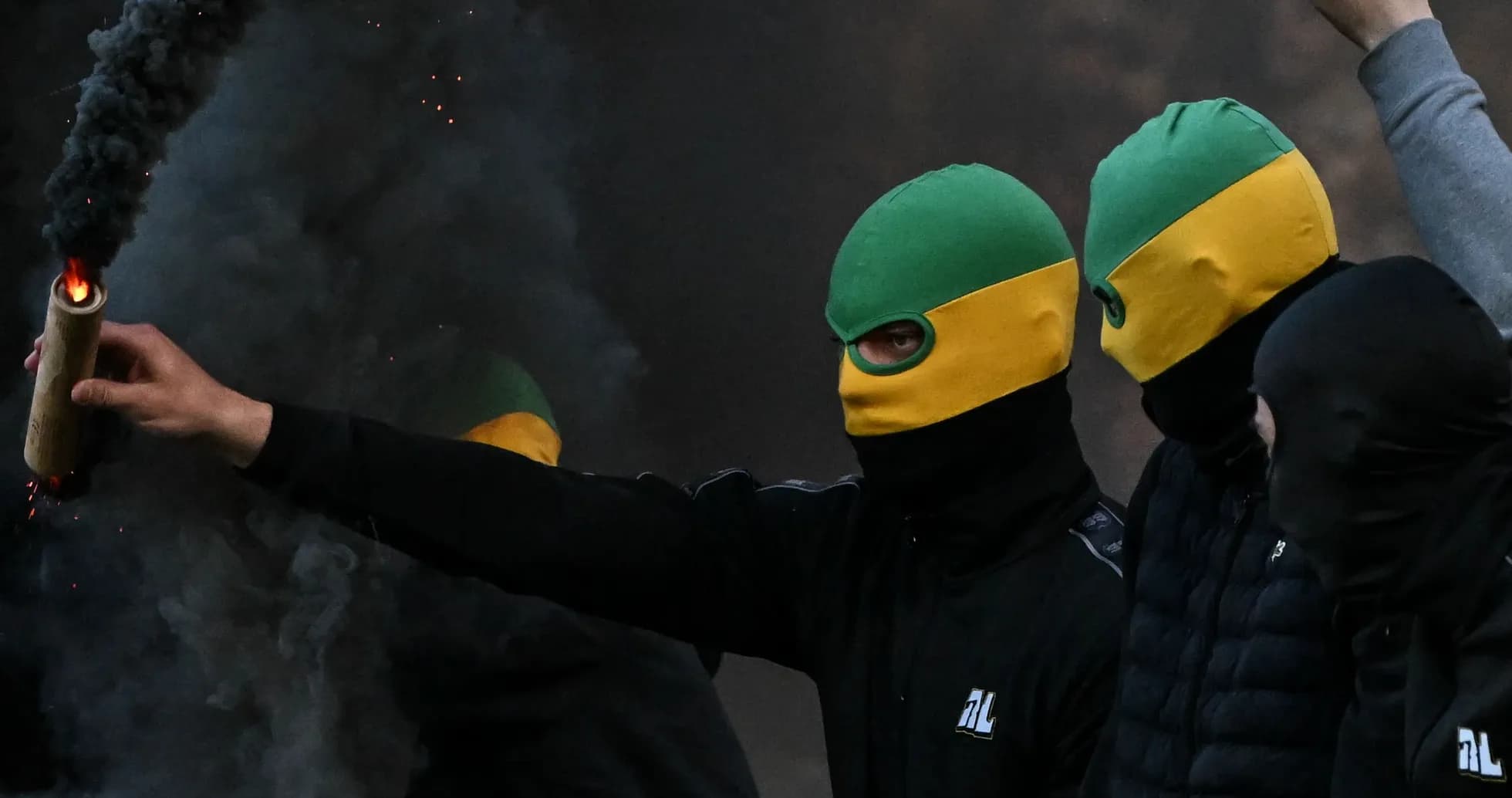 Grupo de personas con pasamontañas y bengalas