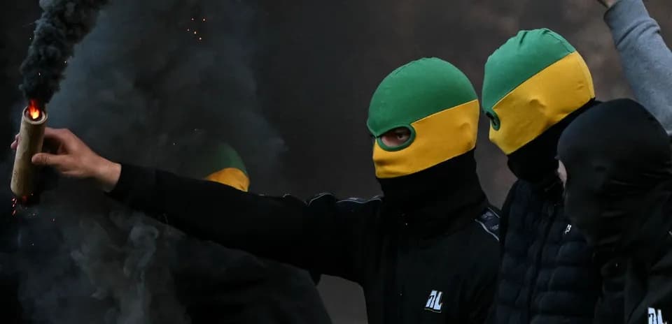 Grupo de personas con pasamontañas y bengalas