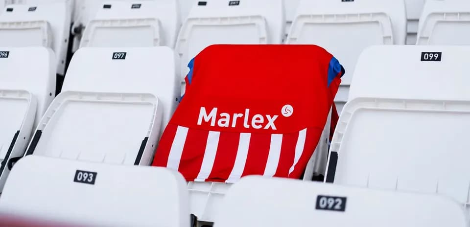 Camisa roja con rayas blancas en asiento vacío