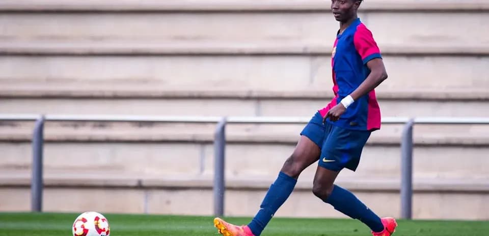 Jugador de fútbol en acción con balón en campo