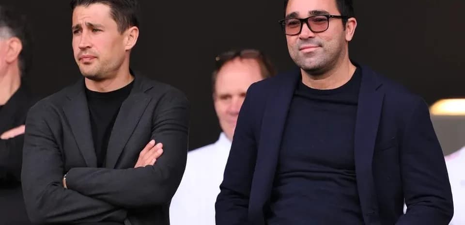 Dos hombres observando un evento deportivo desde la grada