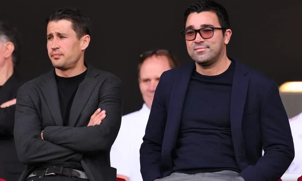Dos hombres observando un evento deportivo desde la grada