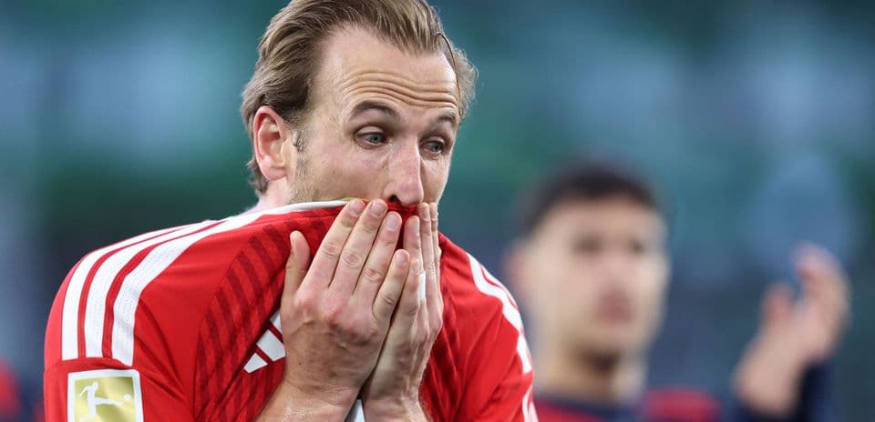 Jugador de fútbol con camiseta roja cubriendo su rostro