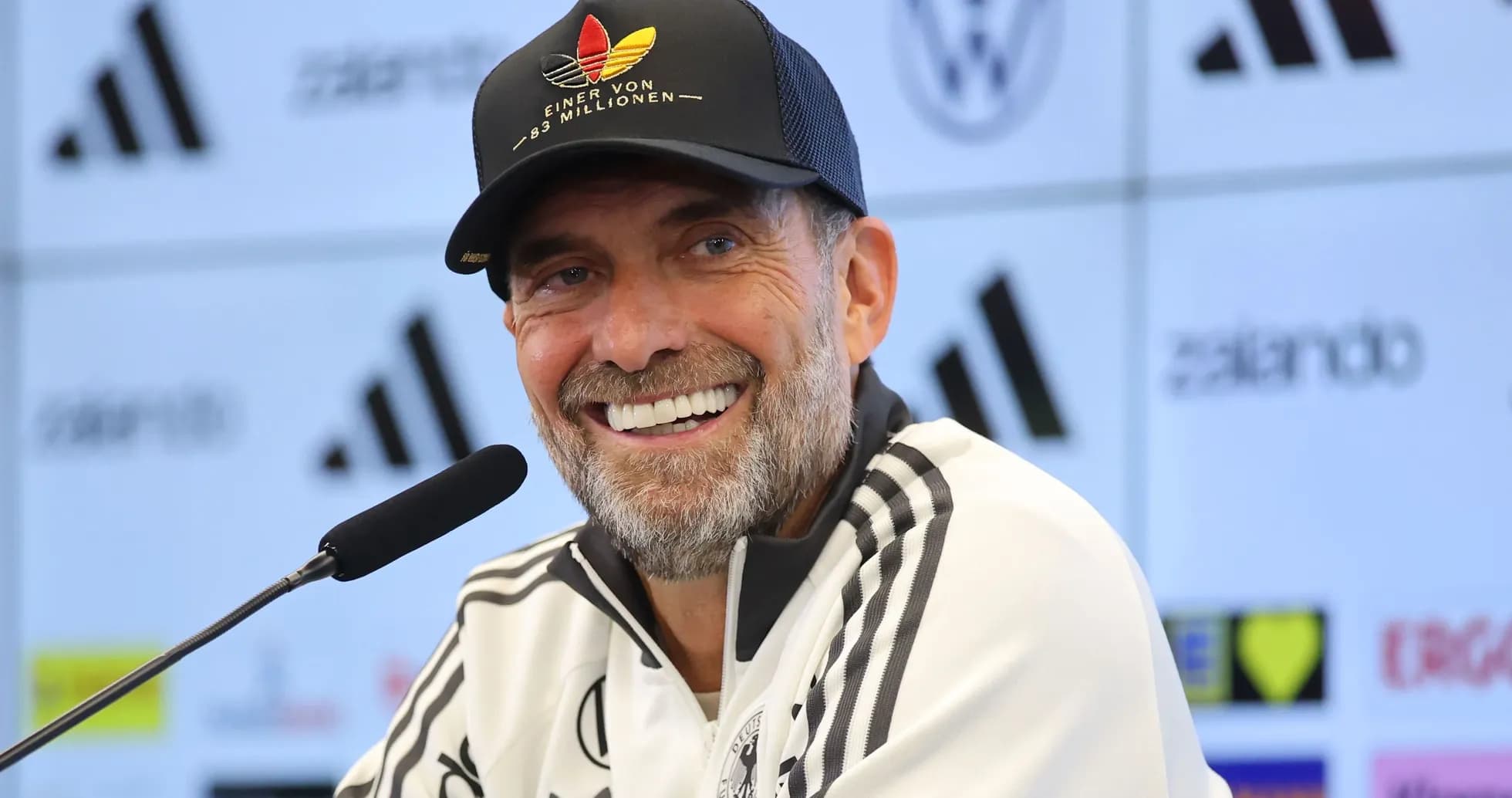 Entrenador sonriente en conferencia de prensa