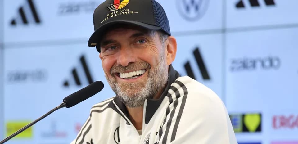 Entrenador sonriente en conferencia de prensa