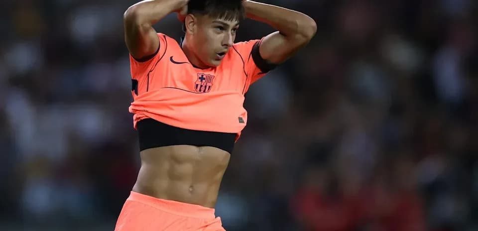 Jugador de fútbol ajustándose la camiseta en el campo