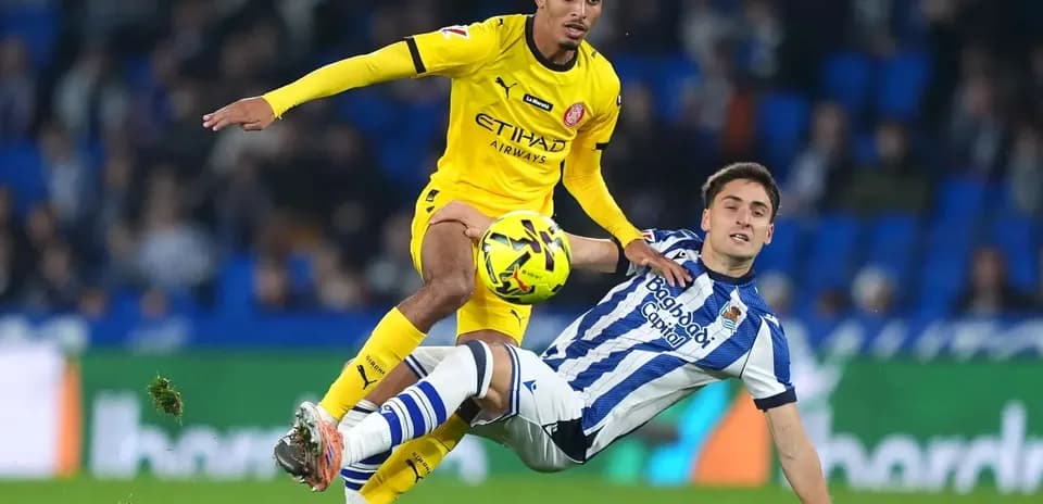 Jugador de Girona superando a rival de Real Sociedad