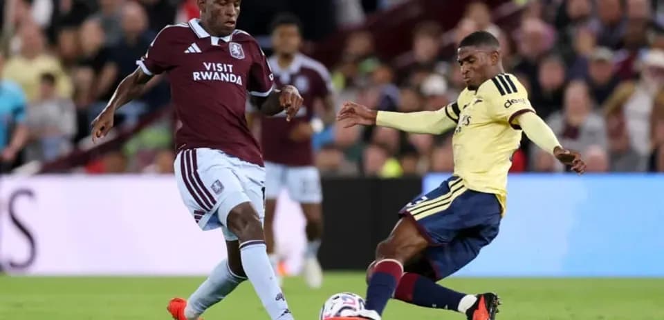 Jugador de Aston Villa desafiando a oponente de Arsenal