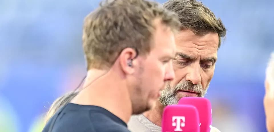 Dos hombres conversando en un evento deportivo