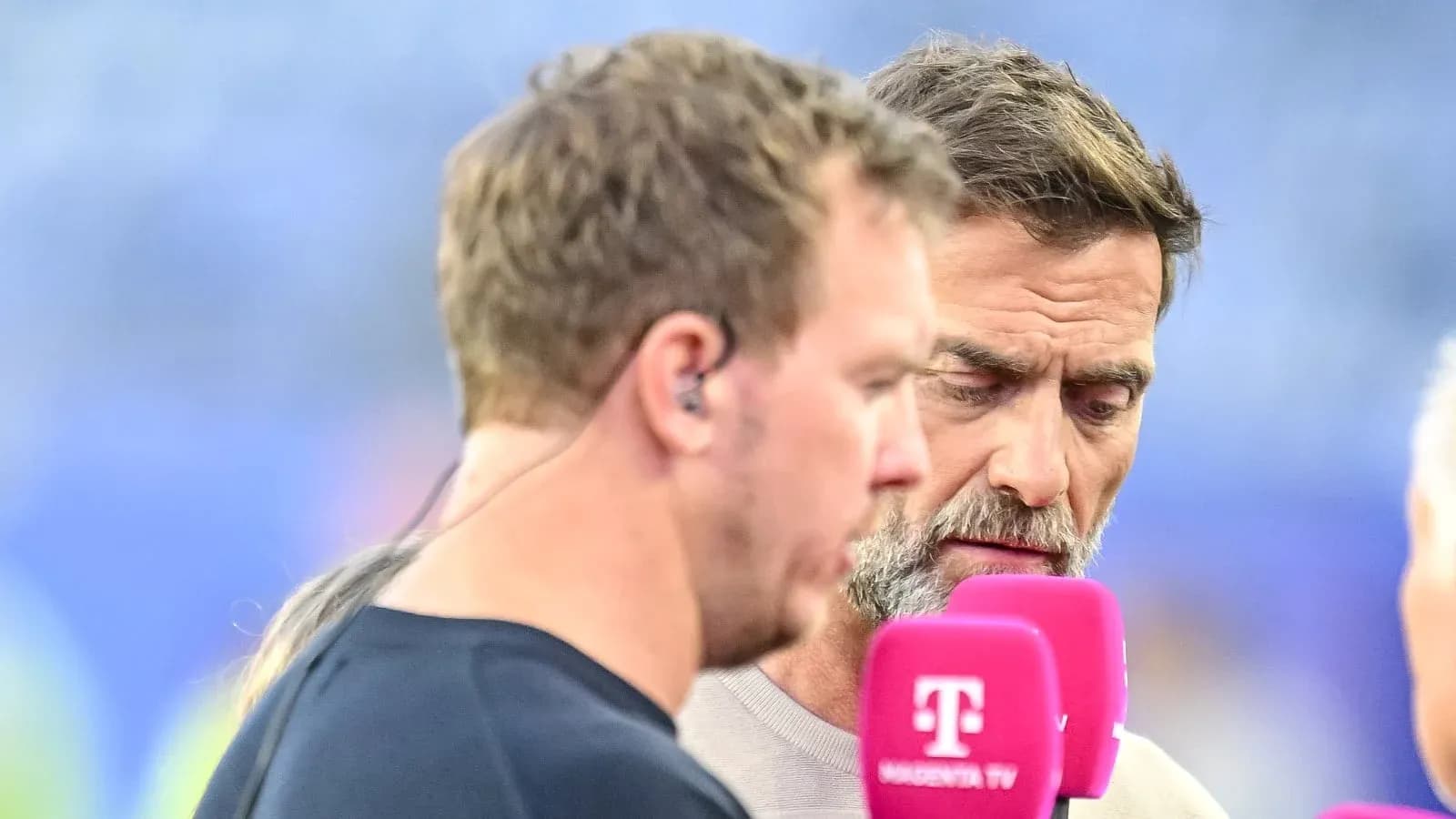 Dos hombres conversando en un evento deportivo