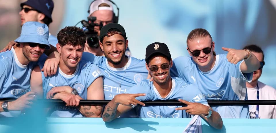 Cinco aficionados de Manchester City posando sonrientes