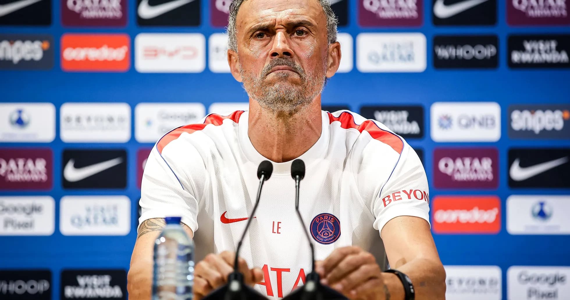 Entrenador en conferencia de prensa con micrófonos