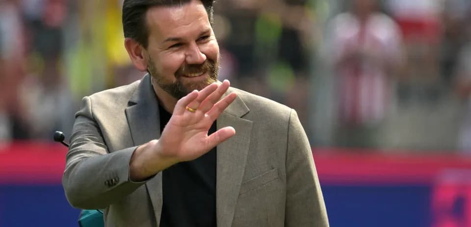 Hombre sonriendo y saludando en un evento deportivo