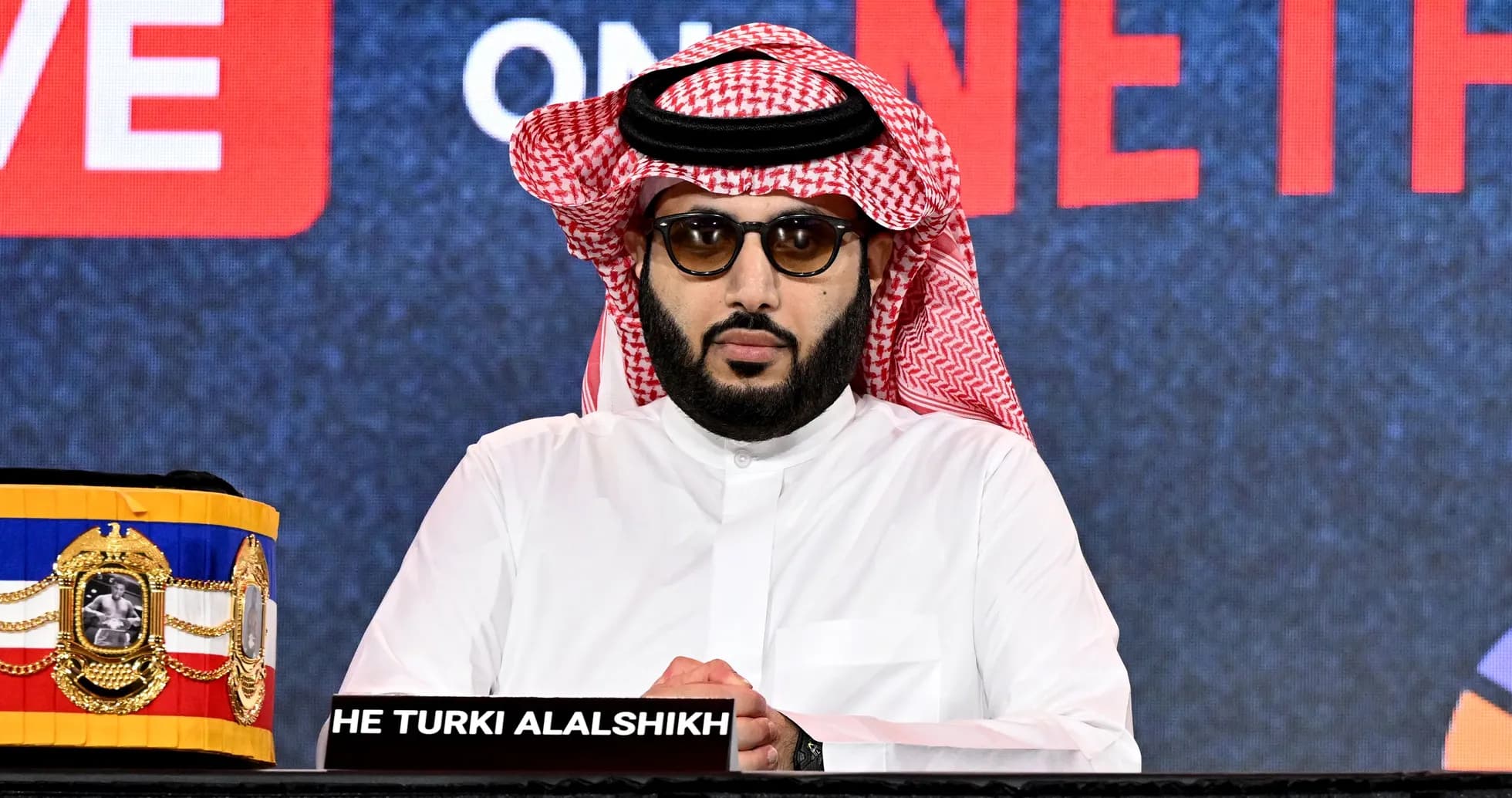 Hombre con gafas en conferencia de prensa