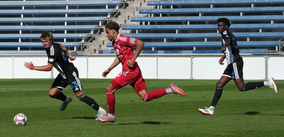 Jugadores corriendo en partido de fútbol