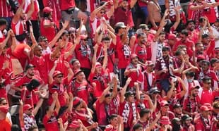 Aficionados animando con camisetas rojas en el estadio