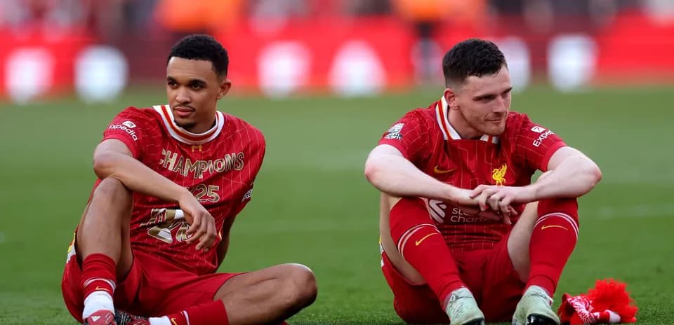 Jugadores de Liverpool sentados en el campo tras partido