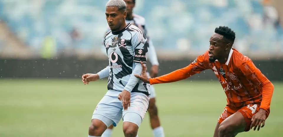 Jugador con camiseta azul siendo marcado por oponente