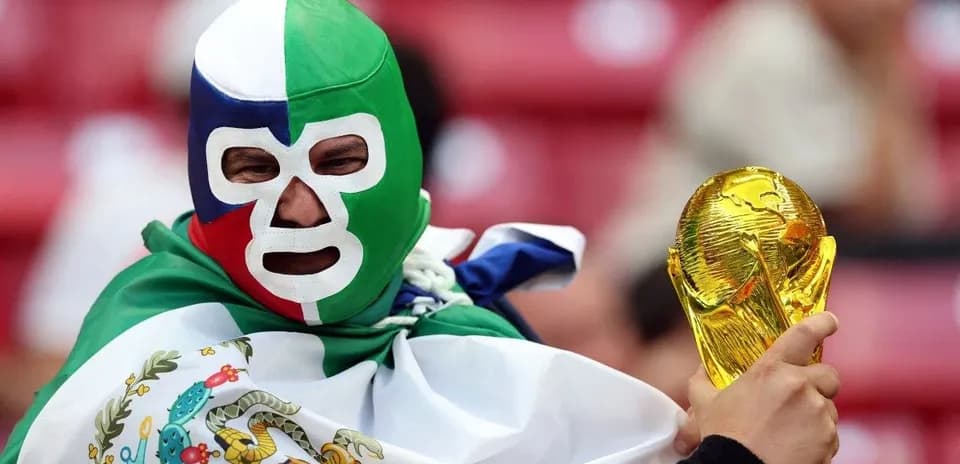 A fan in a green mask holding a trophy