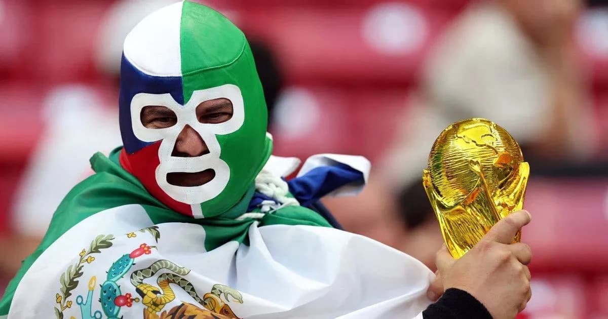 A fan in a green mask holding a trophy