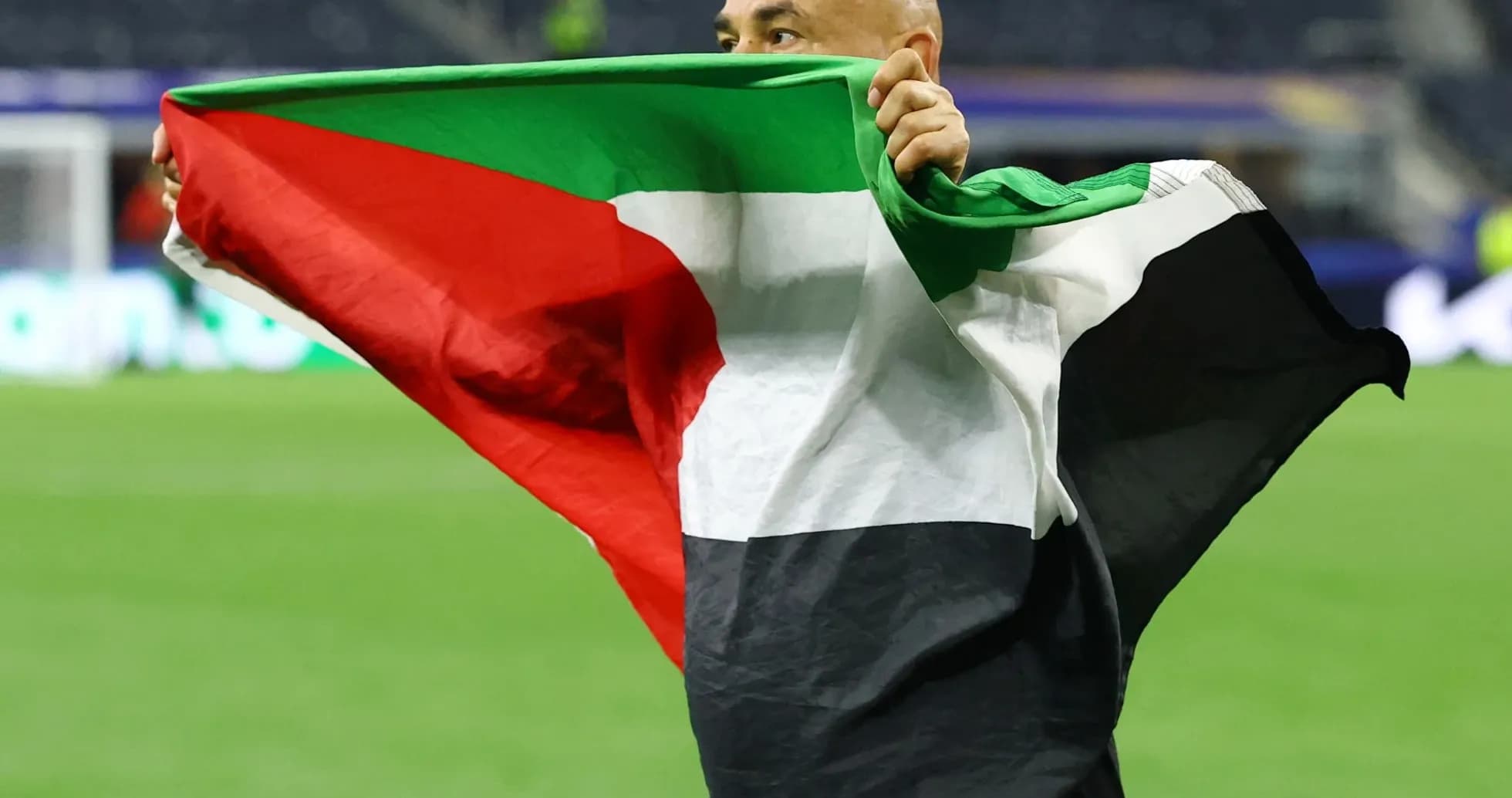 Persona sosteniendo una bandera en el campo de fútbol