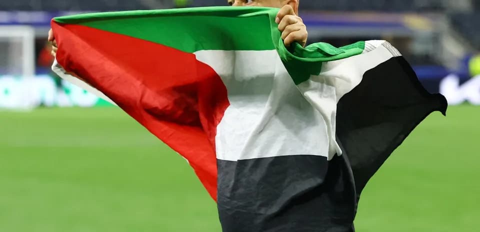 Persona sosteniendo una bandera en el campo de fútbol