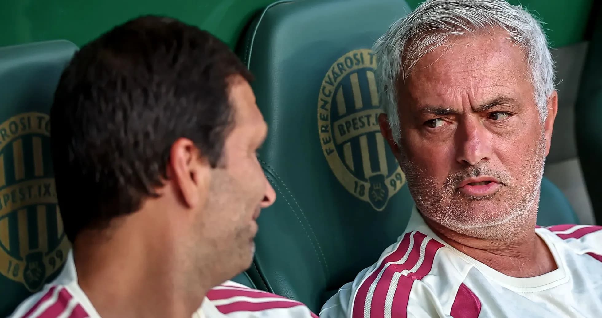 Entrenador conversando con jugador en banquillo