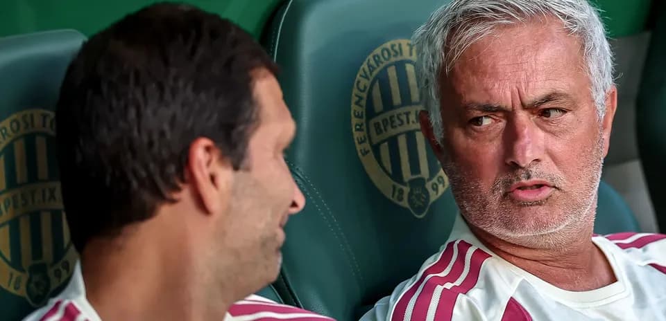 Entrenador conversando con jugador en banquillo
