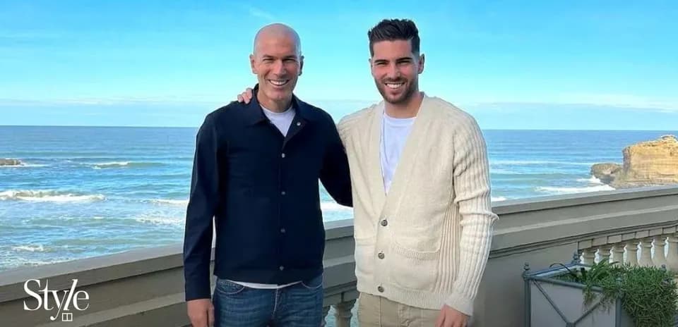 Dos hombres posando frente al mar en la playa