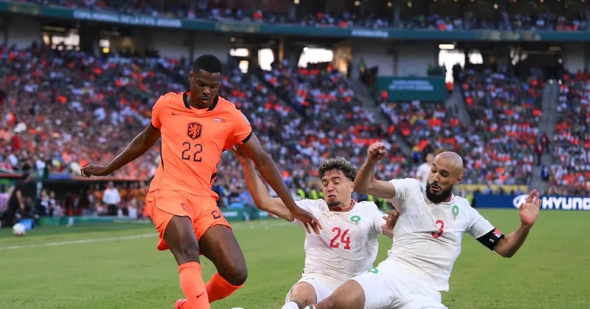 Jugador de Países Bajos driblando entre dos defensores