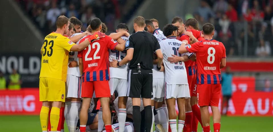 Jugadores de dos equipos en círculo durante partido